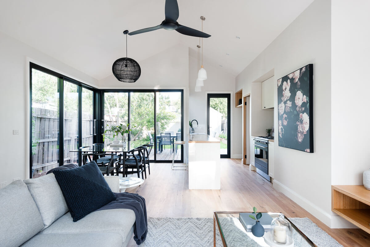 Select the best property stylist: Pitched ceiling dining and living room with striking black fixtures.