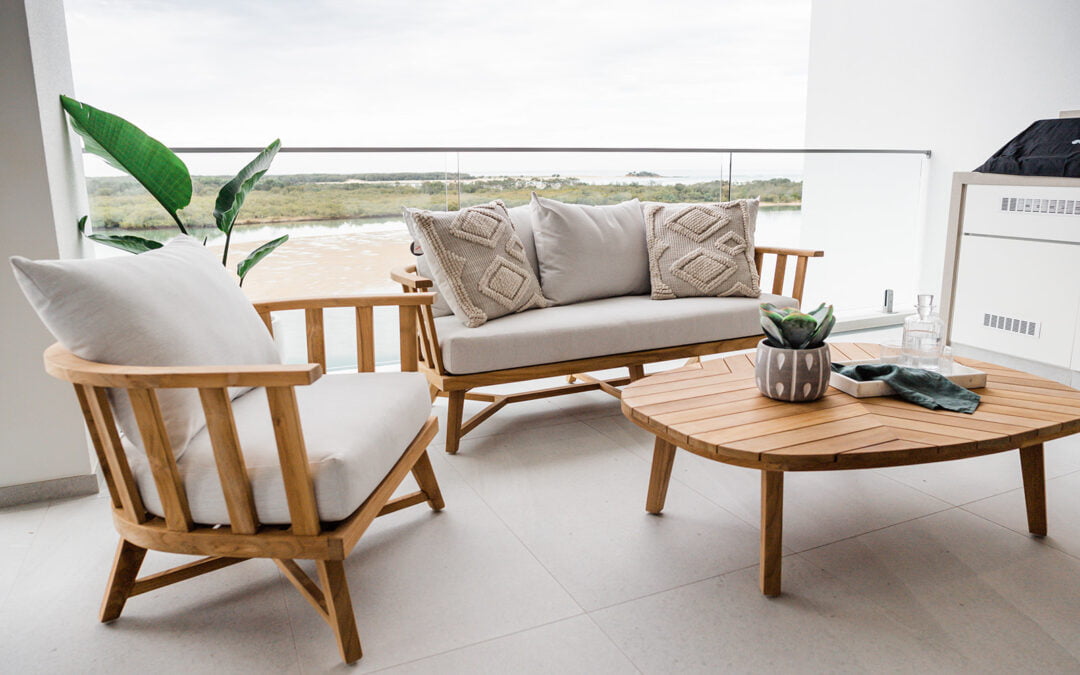 Timber and beige cushioned outdoor furniture with a coastal view