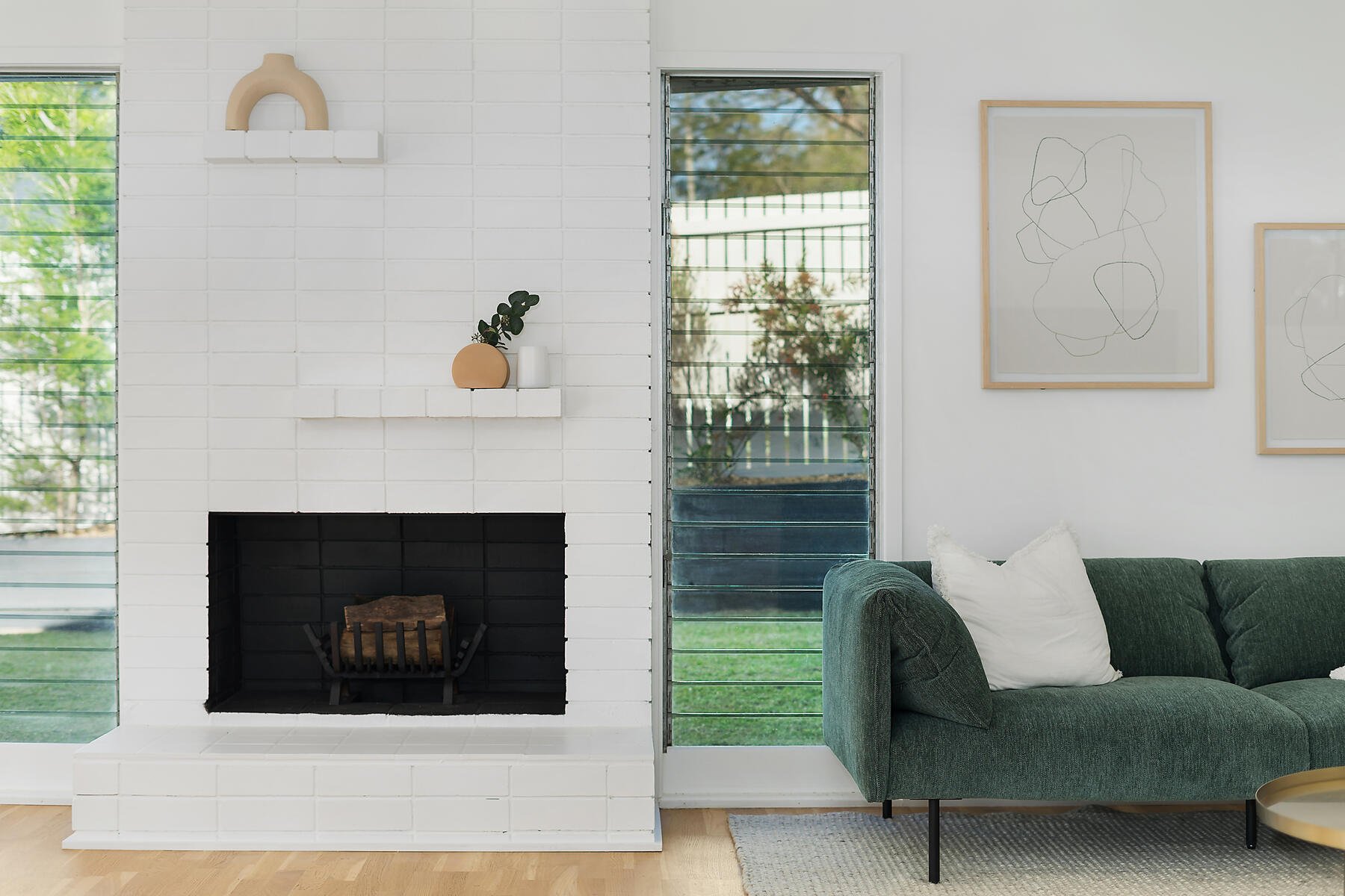 Feature fireplace with louvre windows either side and built in staggered shelving above.